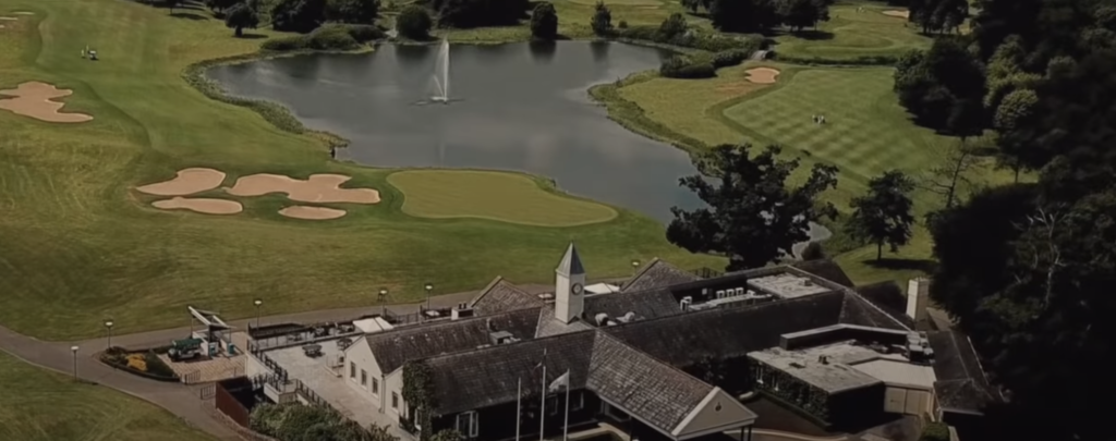 Aerial view of a lush golf course with fountain lake.